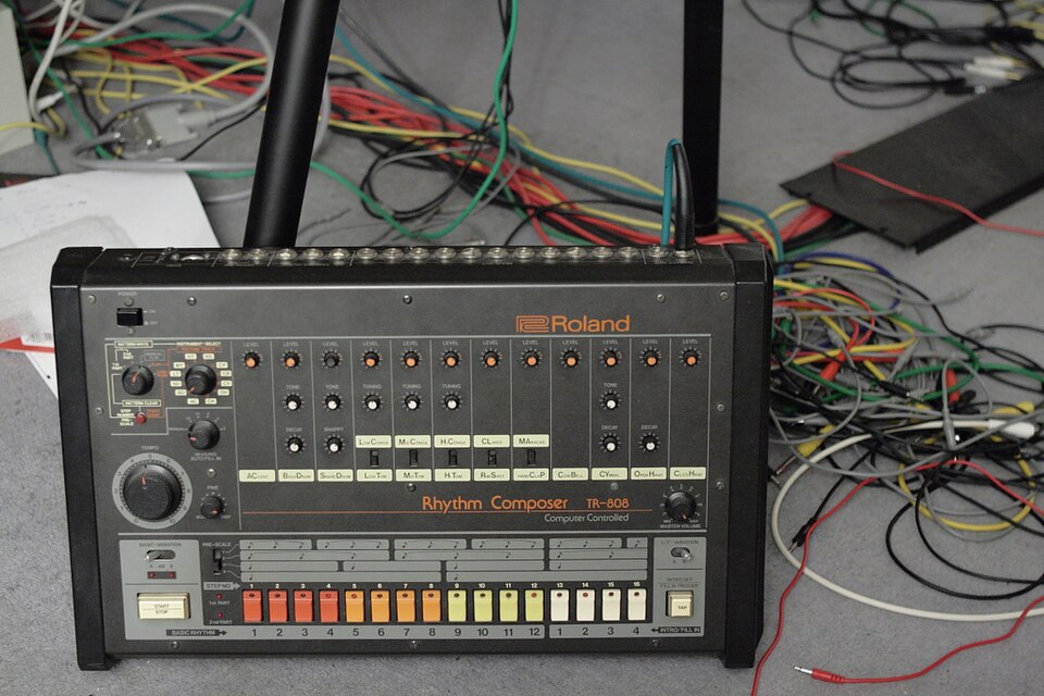 A working Roland TR-808 surrounded by patch cables in an electronic music studio